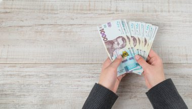 Kopya alanı olan bir iş kadınının elinde 1000 Hryvnia banknotları. Yukarıdan görüntüle.