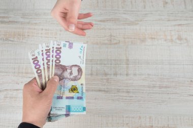 Elinde 1000 Hryvnia var. Kadınların elleri aşağı yukarı Hryvnia 'dır. Boşluğu kopyala.