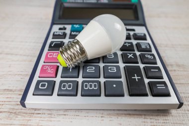 Hesap makinesinde enerji tasarrufu ampulü. Elektrik tasarrufu kavramı