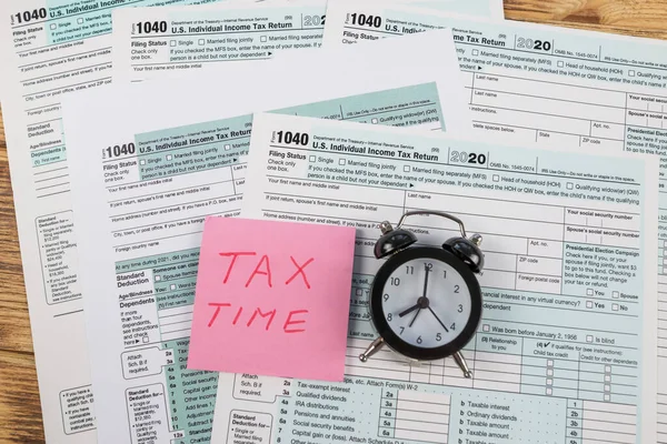 税务表格1040和报警器的顶部视图 课税时间 — 图库照片