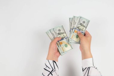Beyaz ellerde izole edilmiş kadın ellerindeki dolarların üst görünümü.