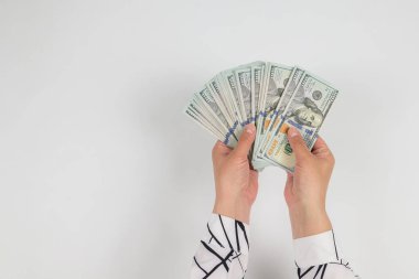 Beyaz ellerde izole edilmiş kadın ellerindeki dolarların üst görünümü.