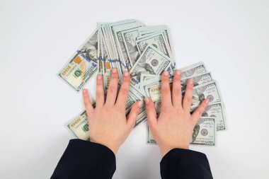 Beyaz ellerde izole edilmiş kadın ellerindeki dolarların üst görünümü.