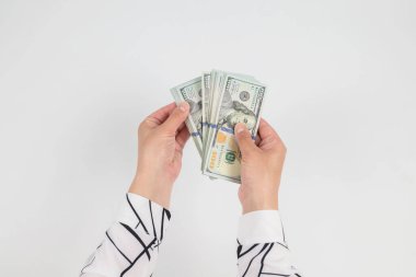 Beyaz ellerde izole edilmiş kadın ellerindeki dolarların üst görünümü.