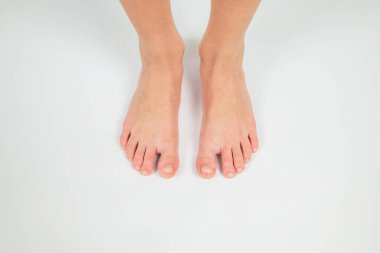 Ayaklar beyaz arka planda, ön manzara. Genç bir çocuğun iki bacağı..