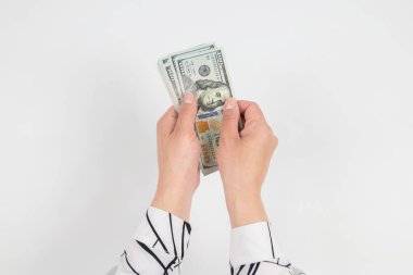 Beyaz ellerde izole edilmiş kadın ellerindeki dolarların üst görünümü.