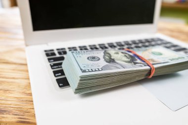 Dizüstü bilgisayarda bir yığın dolar. Yakın plan.