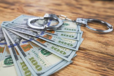 Metal kelepçeler ve dolar tahtadan arka planda