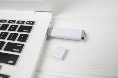 USB sürücüsü beyaz arkaplandaki bir dizüstü bilgisayara bağlanır