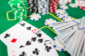  gambling.Poker herní koncept. Poker karty s žetony a dolary na zeleném pokerovém stole.