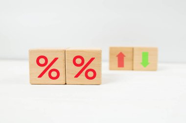 Faiz kavramı finansal ve ipotek oranlarını belirler. % simgesi olan tahta bloklar beyaz üzerine yukarı ve aşağı ok