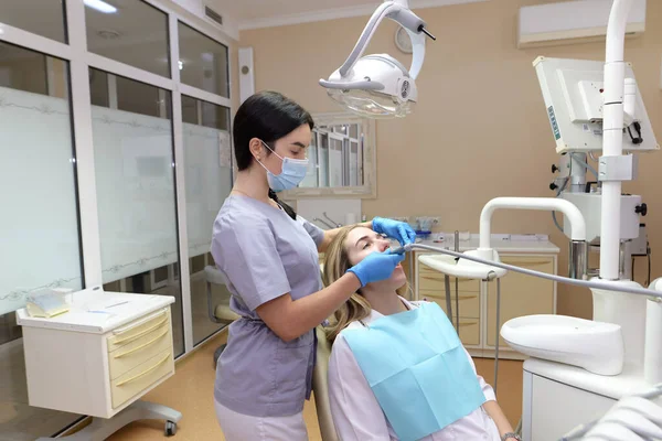 Een Vrouwelijke Tandarts Controleert Tanden Van Een Jonge Vrouwelijke Patiënt — Stockfoto