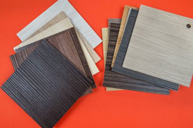 Turuncu arka planda lamba levhalar. Döşeme ve iç dizayn için ahşap desenli laminat veya parke örnekleri. Ahşap zemin üretimi