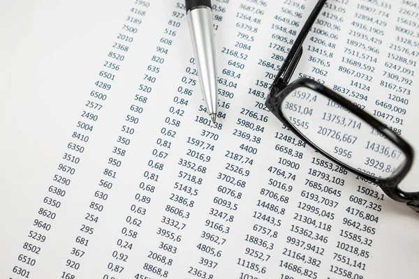 pen glasses on a pile of paper documents. Business concept. Report, pay taxes, finance.Business, finance and audit research concept. Different numbers on paper. Statistics.