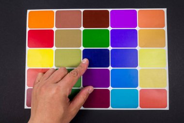 El bir renk kataloğundan bir renk seçer. Parmağı olan kişi boyanmak için palette seçilen rengi gösterir. Renk kataloğu fanı. İç tasarım seçimi kavramı