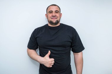 Tişörtlü sporcu portresi başparmağını kaldırıyor ya da havalı bir jest yapıyor.