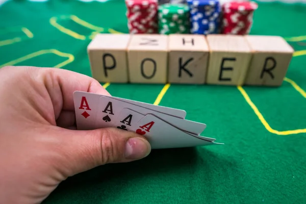 player shows  play card aces on a green table in a casino with chips. gambling