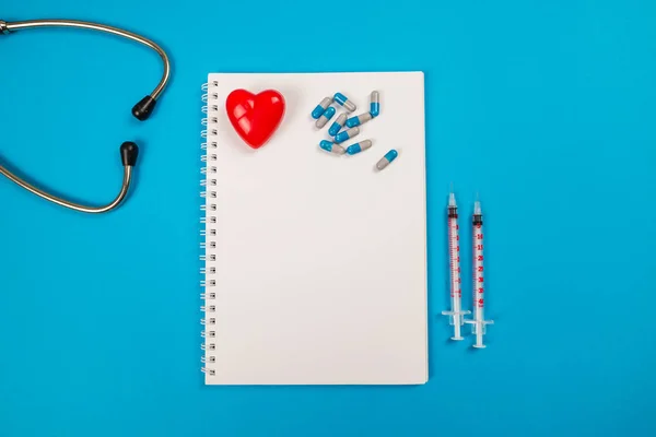 Top View Red Heart Stethoscope Pill Notepad Isolated Blue Background — Φωτογραφία Αρχείου