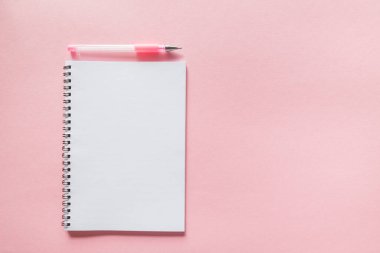 Pembe arka planı olan beyaz bir defter. kopyalama alanı. Düzen, şablon.