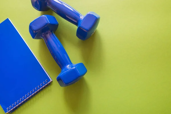 Fitness Weight Loss Concept Blue Dumbbells Notepad Green Background Copy — Φωτογραφία Αρχείου