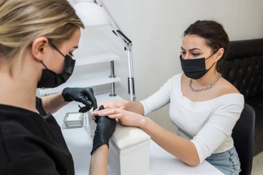 Closeup parmak tırnak bakım Güzellik Salonu manikür uzmanı tarafından. Manikürcü kütikül profesyonel kerpeten manikür ve pedikür için temizleyin.