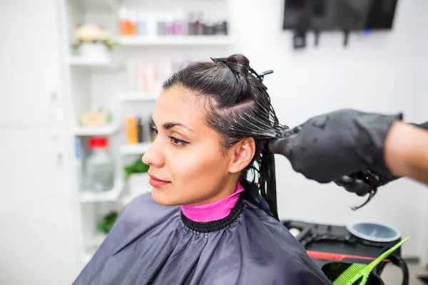 The hairdresser applies professional liquid keratin to the client\'s hair. A girl does keratin hair strengthening in a beauty salon. Hair care.