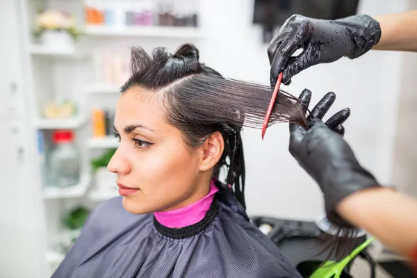 The hairdresser applies professional liquid keratin to the client\'s hair. A girl does keratin hair strengthening in a beauty salon. Hair care.