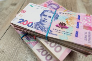 packs of 200 hryvnias on a wooden table.