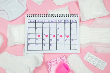 calendar photo, underwear, menstrual cup, sanitary napkins on isolated pastel pink background. The concept of menstruation, women's creative days.