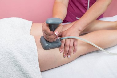 Close-up of a woman undergoing an anti-cellulite massage procedure in a beauty salon