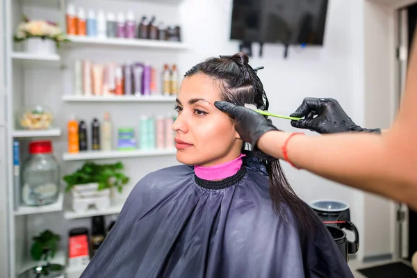 The hairdresser applies professional liquid keratin to the client's hair. A girl does keratin hair strengthening in a beauty salon. Hair care.