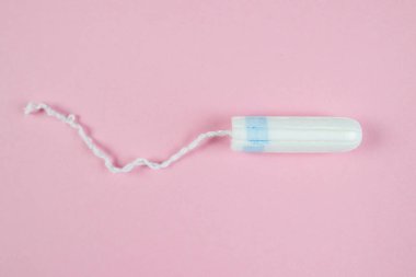 female tampon on a pink background. Hygienic white tampon for women. Cotton swab. Menstruation, Tampons on a pink background.