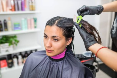 Kuaför müşterinin saçına profesyonel sıvı keratin uygular. Bir kız kuaförde keratin saç güçlendiriyor. Saç bakımı.
