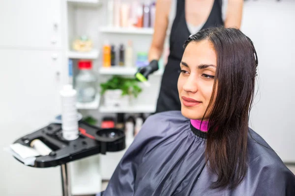 The hairdresser applies professional liquid keratin to the client\'s hair. A girl does keratin hair strengthening in a beauty salon. Hair care.