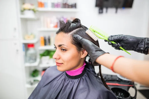 The hairdresser applies professional liquid keratin to the client\'s hair. A girl does keratin hair strengthening in a beauty salon. Hair care.