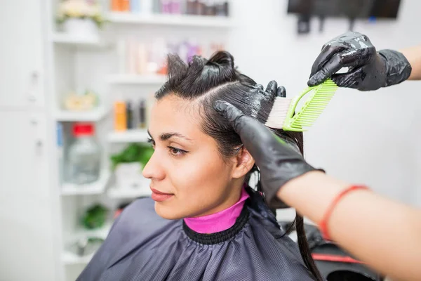 The hairdresser applies professional liquid keratin to the client\'s hair. A girl does keratin hair strengthening in a beauty salon. Hair care.