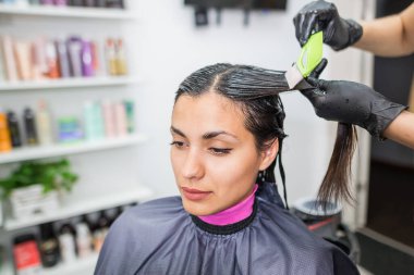 Kuaför müşterinin saçına profesyonel sıvı keratin uygular. Bir kız kuaförde keratin saç güçlendiriyor. Saç bakımı.