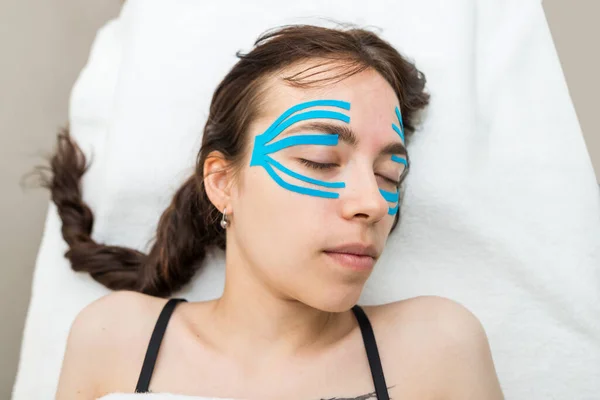 Facial tape, close-up of a girl\'s face with an anti-wrinkle cosmetology tape. Aesthetic taping of the face. Non-invasive anti-aging lifting method to reduce wrinkles