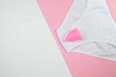 külot ve regl kupası pembe ve beyaz arka planda fotokopi alanı görünümlü