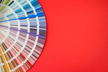 Renk rehberi yaklaş. Tasarım için çeşitli çiçekler. Kırmızı arkaplanda renk paleti vantilatörü. Grafik tasarımcısı renk paleti rehberinden renk seçer. Renk kumaşı kataloğu