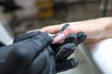 Çivi bakımı konsepti. Manikürcü, kuaförde müşterisi olan bir kıza manikür yapıyor..