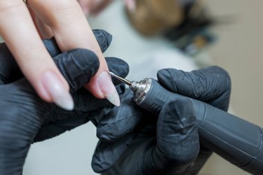 Çivi bakımı konsepti. Manikürcü, kuaförde müşterisi olan bir kıza manikür yapıyor..