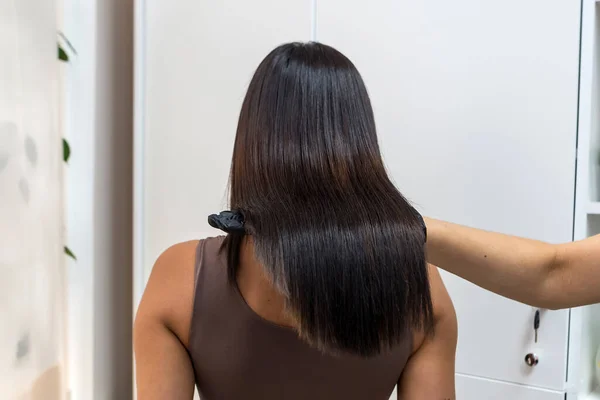 Saturated healthy shiny hair after dyeing. Recovery framework concept.Beautiful model girl with shiny brown and straight long hair . Keratin straightening . Treatment, care and spa procedures. Smooth hairstyle
