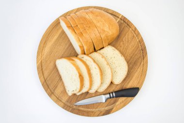 Beyaz arka planda dilimlenmiş ekmek ve bıçak. Beyaz ekmek dilimleri. Beyaz arkaplanda baton.