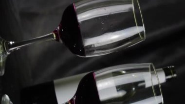 Koyu arkaplanda bir kadeh kırmızı şarap. Yavaş çekim