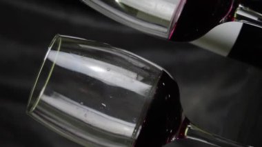 Koyu arkaplanda bir kadeh kırmızı şarap. Yavaş çekim