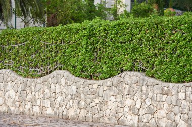 Özel bir evde çitlerle çevrili taş çitler.