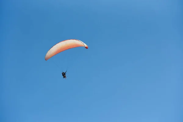 Paragliding se dvěma lidmi proti modré obloze — Stock fotografie