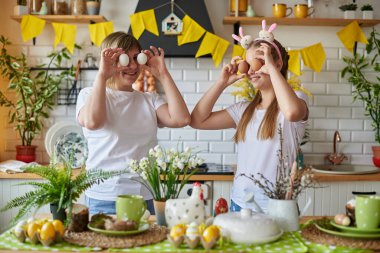 Anne ve kızı Paskalya için hazırlanırken yumurtalarla şakalaşırken iyi eğlenceler.