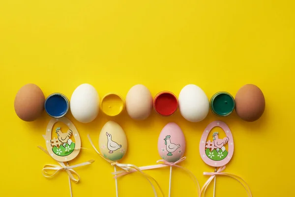 Modèle de Pâques avec œufs de poulet et peintures sur fond jaune Images De Stock Libres De Droits